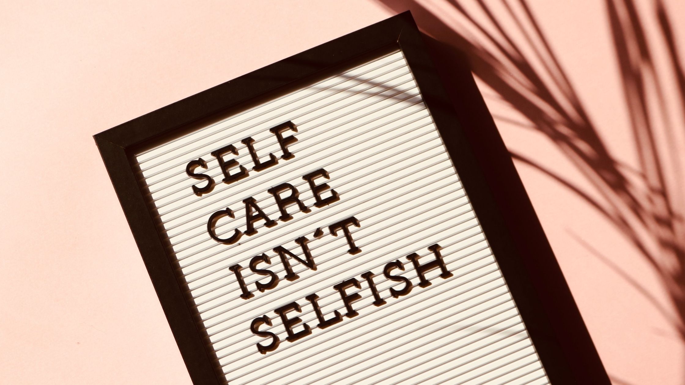 A picture of a letter board saying "Self care isn't selfish."
