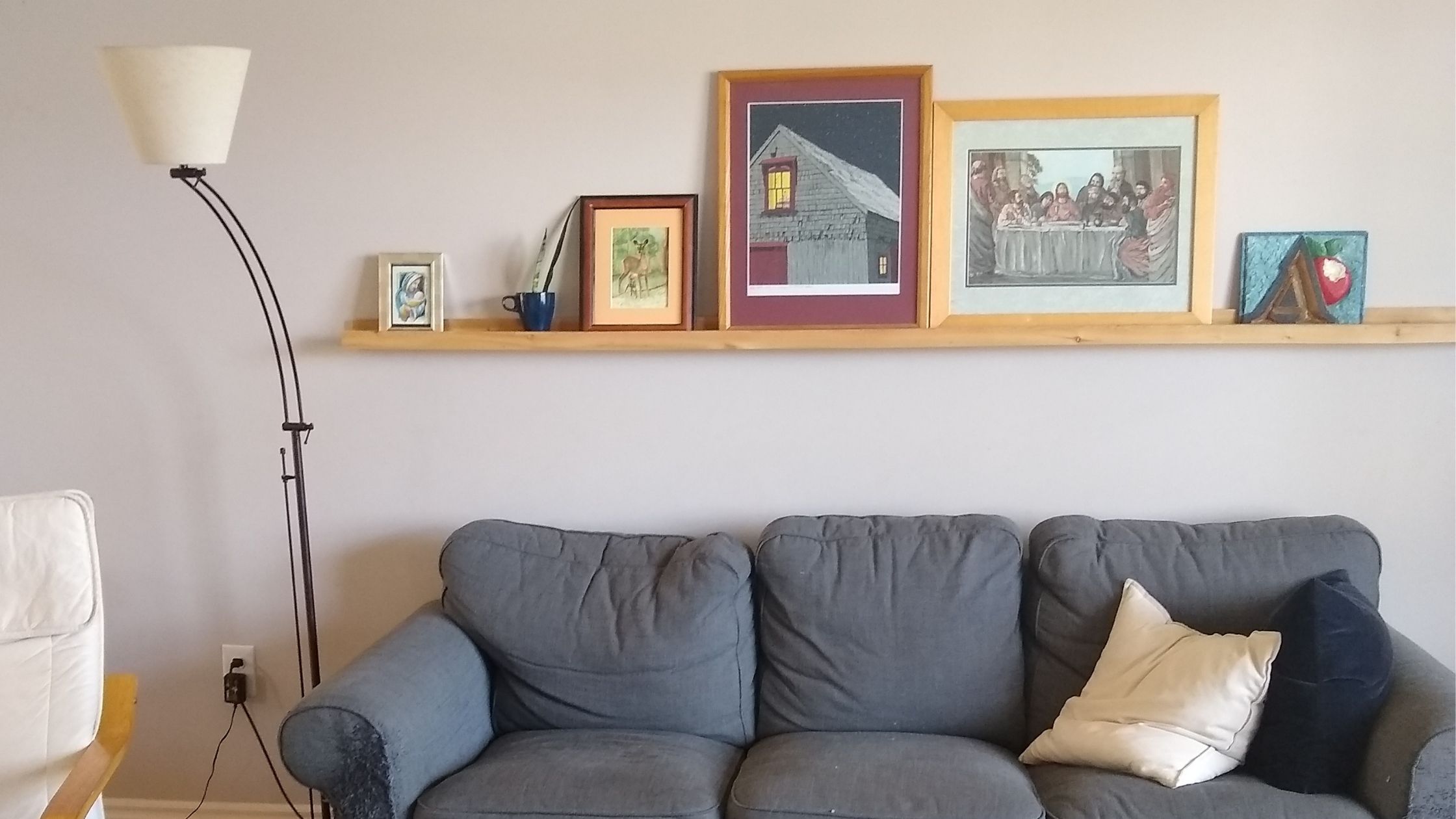A picture of a couch with a picture ledge above it.